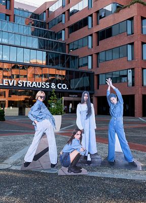 Four cardboard cut outs of models wearing pieces from the Levi's x Ganni collection placed in front of Levi Strauss & Co. headquarters in San Francisco.