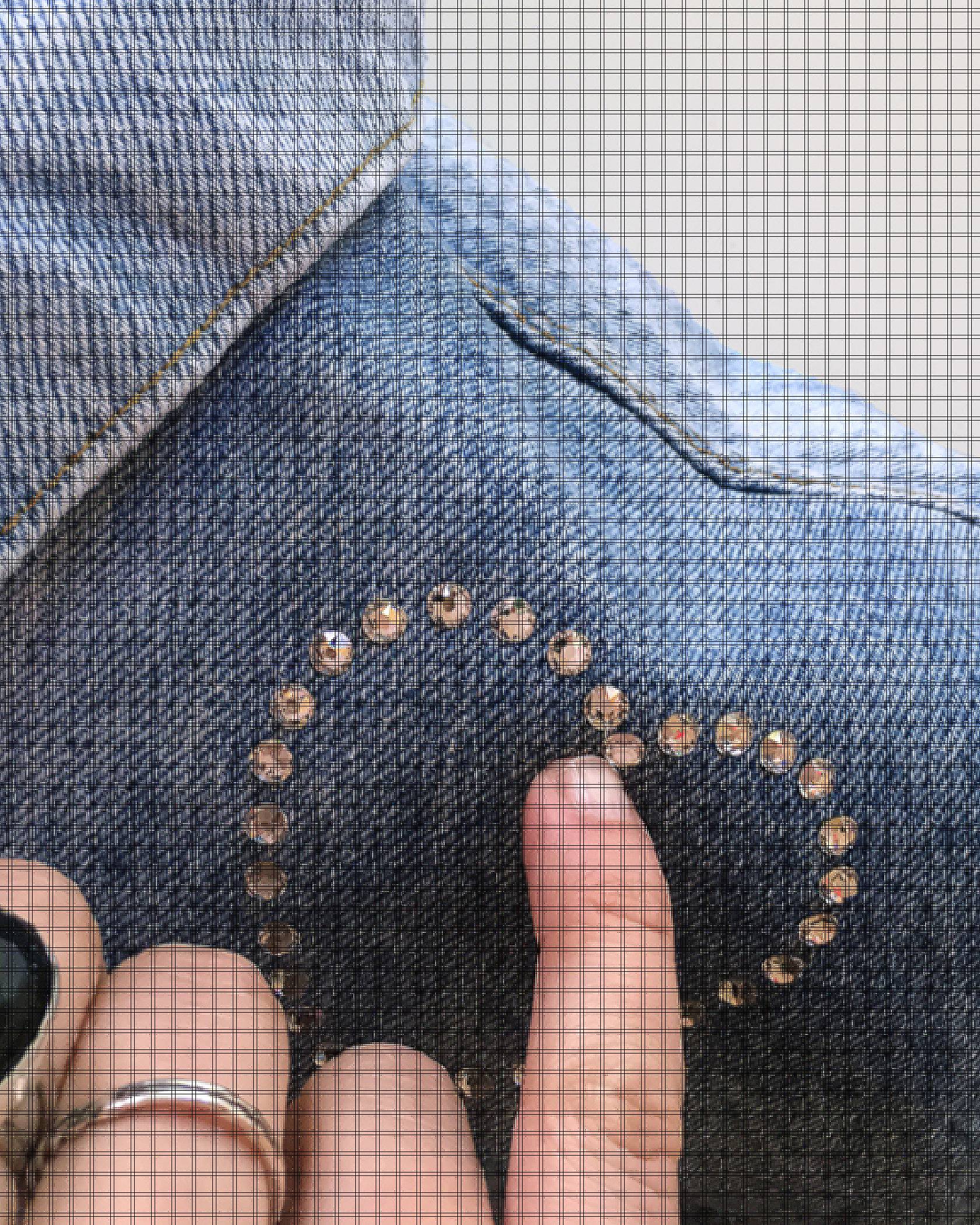 close up crystals on denim jacket with hand