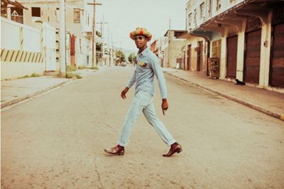 A man wearing 501 jeans walking across the street