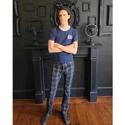 Photo of Matt Barnes in his home. He's wearing a navy tee and navy plaid pants. He has his arms crossed.