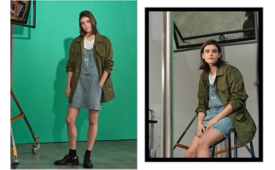 Woman standing in front of a green screen wearing a denim skirt.