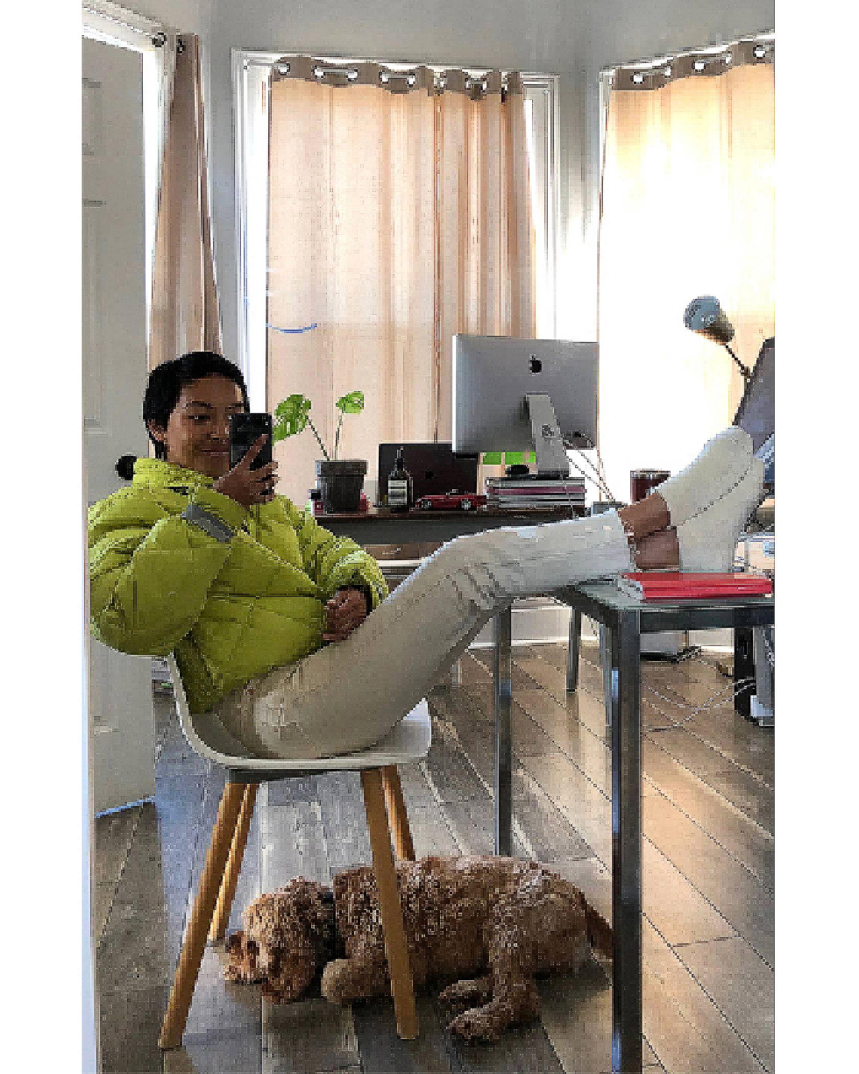 Selfie of Victoria Cao sitting in her office. Her legs are on her desk and she's wearing a lime green Levi's puffer jacket and white Levi's jeans,