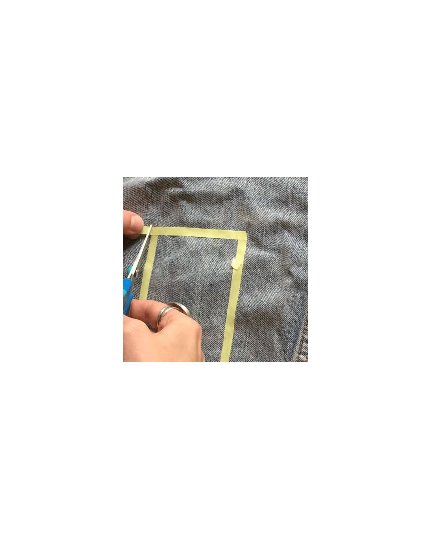 Video of tailor creating a freestyle geometric design with thin yellow tape on a light wash denim trucker jacket.