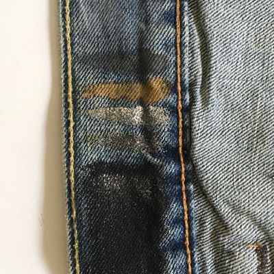 Image of grey, gold, silver, and black paint tested on the inside lining of a trucker jacket.