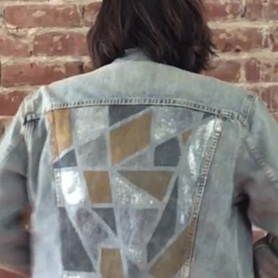 Video of Levi's® tailor, Jen Sharkey, smiling while holding up her newly designed trucker jacket and putting it on.