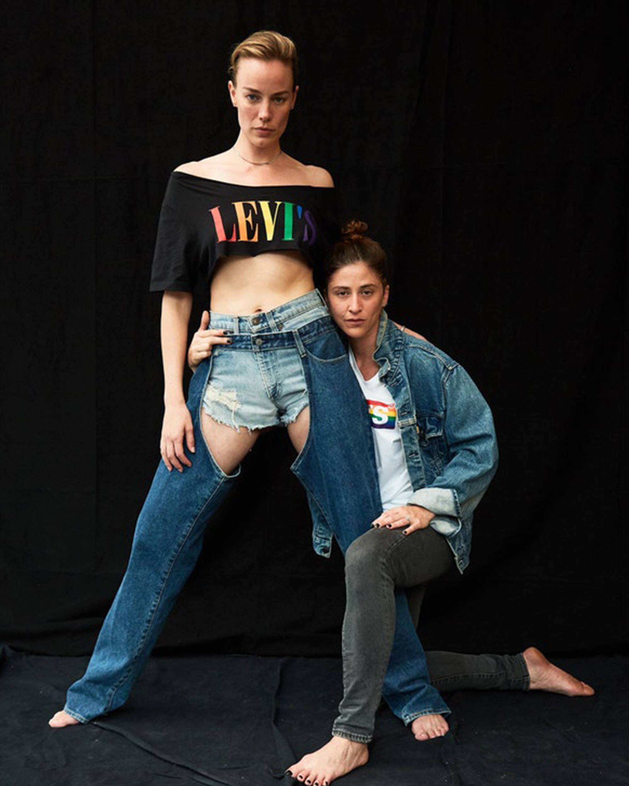 Models in pride apparel against black background