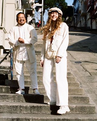 Photo of Gem Mateo and Haley Slocum standing on the street of San Francisco. They are both wearing white head-to-toe.