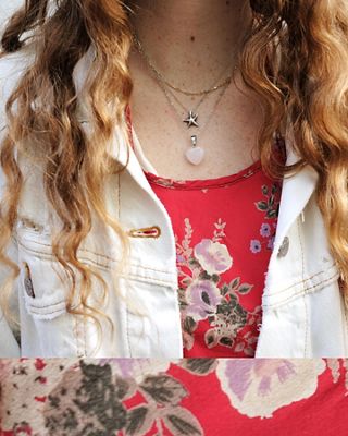 Close-up photo of Haley featuring her necklaces, red floral top, and a sliver of her white Levi's Trucker Jacket.