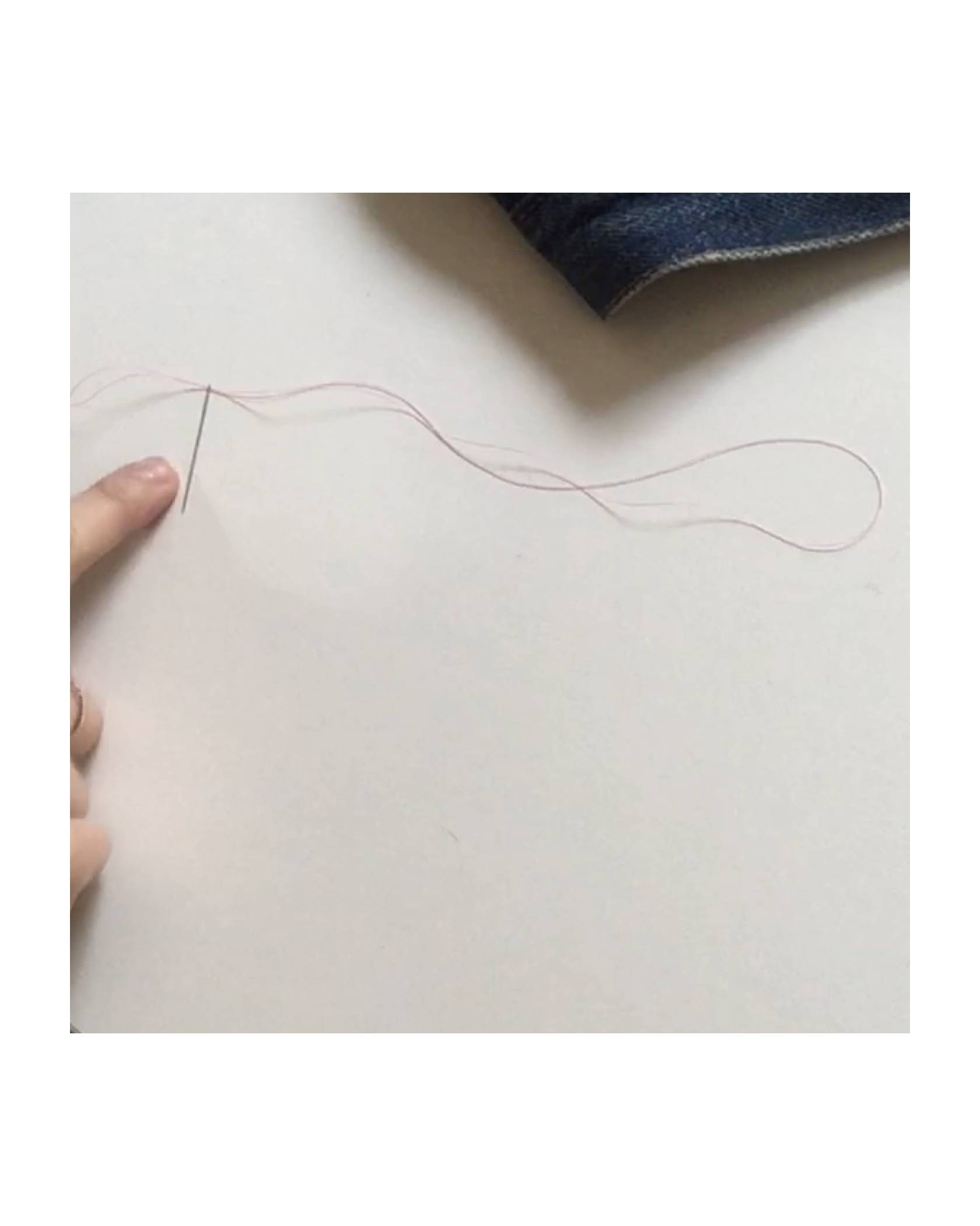 Image of a needle and thread to show how to thread the needle through and leaving a loop on one end.