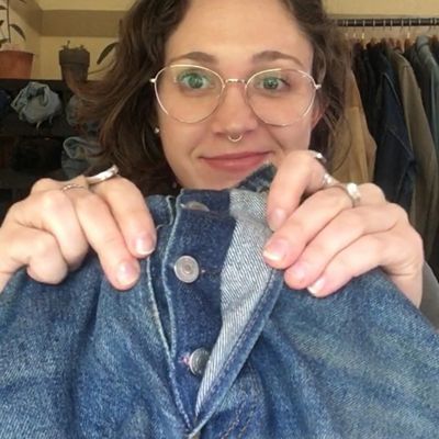 Levi's® Tailor Jen Sharkey holding up a pair of jeans, showing the repaired buttonhole on the button fly of a pair of jeans.
