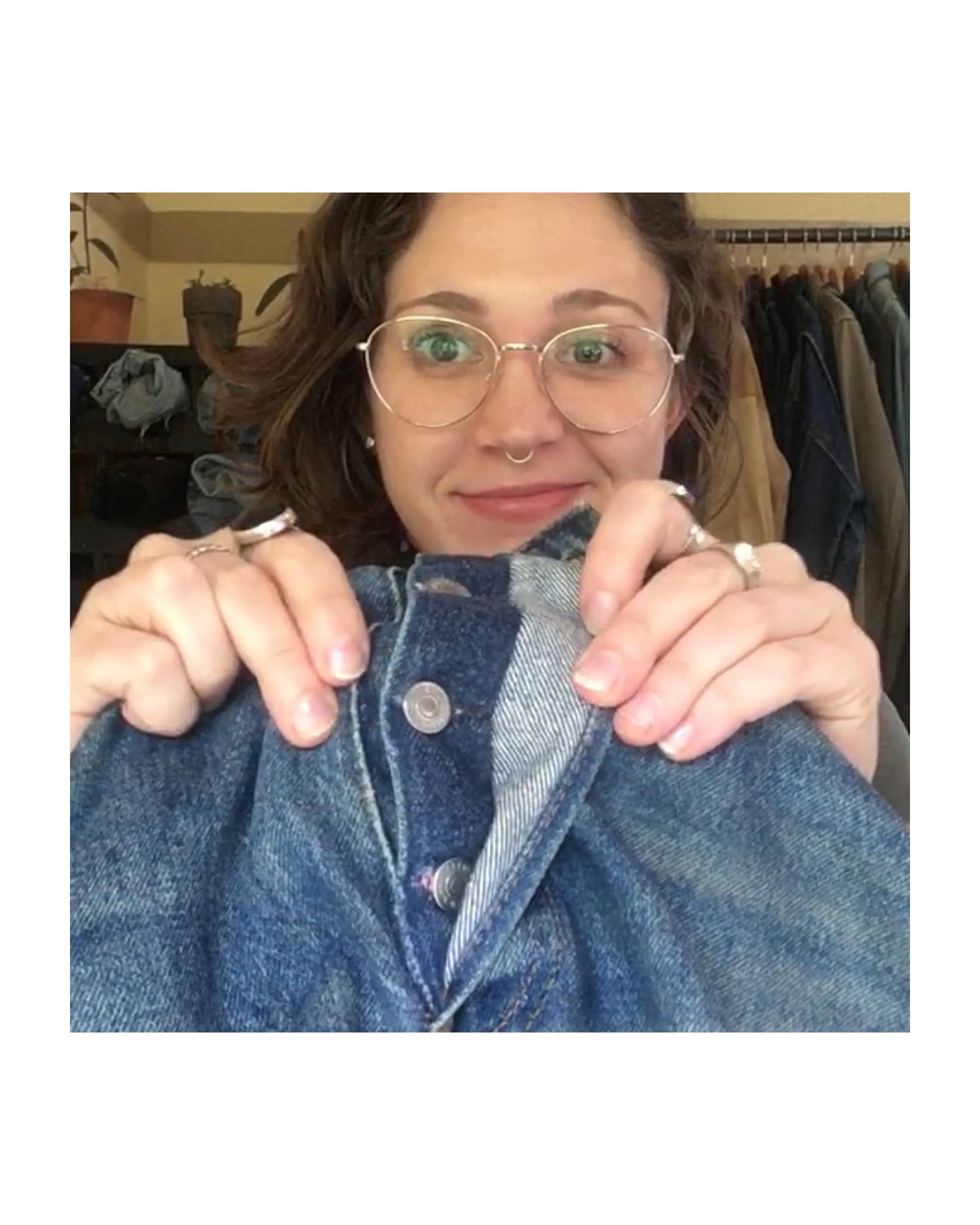 Levi's® Tailor Jen Sharkey holding up a pair of jeans, showing the repaired buttonhole on the button fly of a pair of jeans.