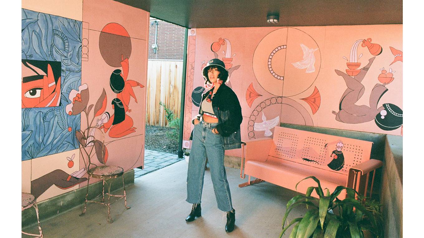 Portrait of Salomée Souag in a room with her murals.