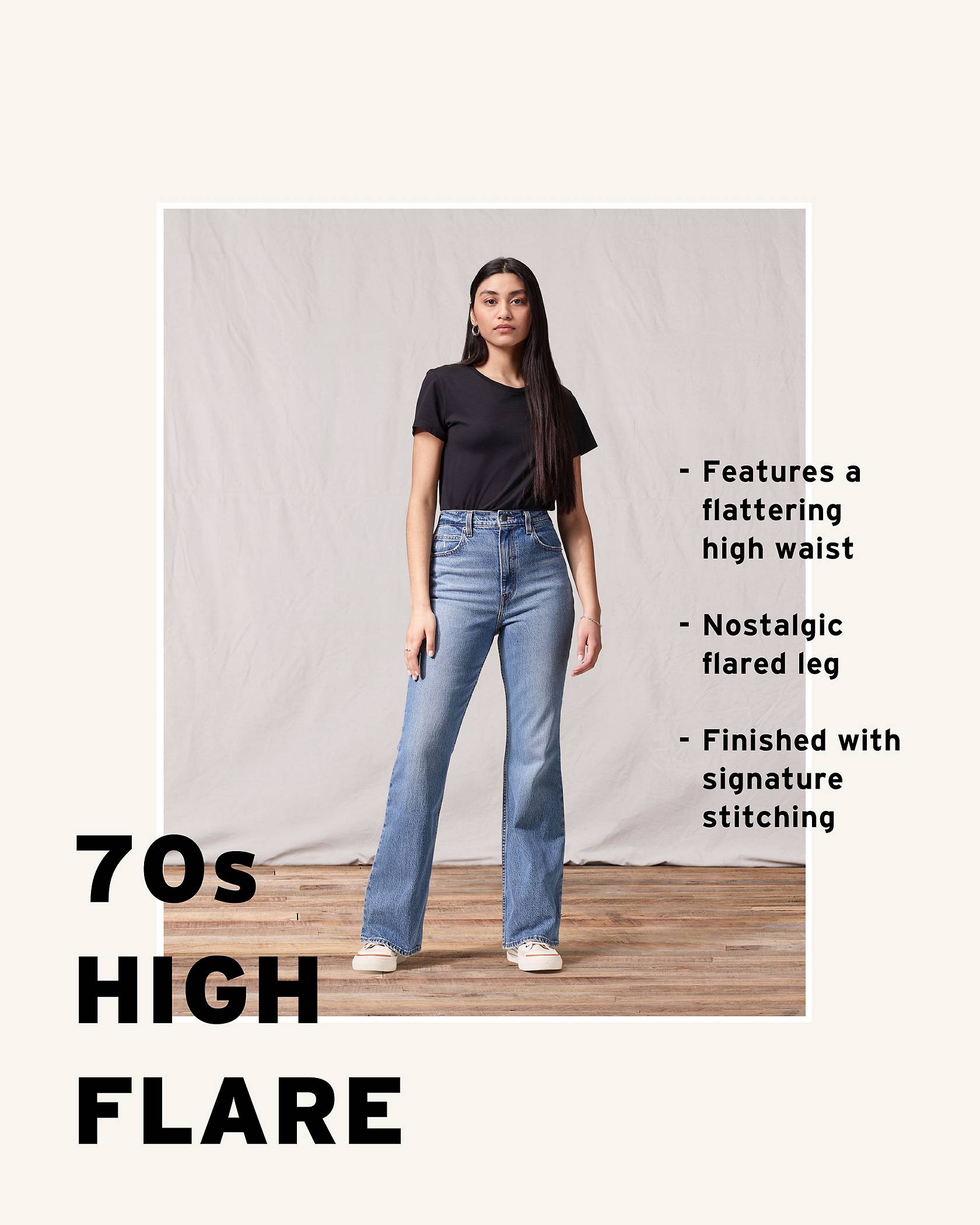 Model wearing a black tee shirt and medium wash 70s High Flare.