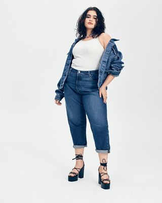 Barbie standing in black heels wearing a denim jacket and denim jeans.