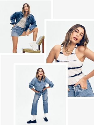 Hailey Bieber wearing a white tank top with blue dye striped, and denim shorts with a denim jacket.