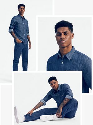 Marcus Rashford wearing dark denim shirt and jeans, and white nikes.