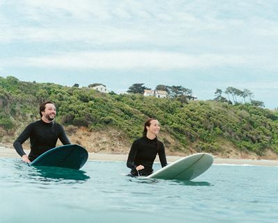 Couple de surfeurs de la Surfrider Foundation en mer sur leur planche