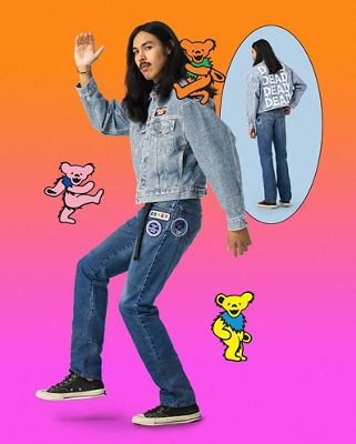 A man standing against a pink background with the different colored grateful dead bears wearing custom pants and trucker jacket from the new collaboration collection