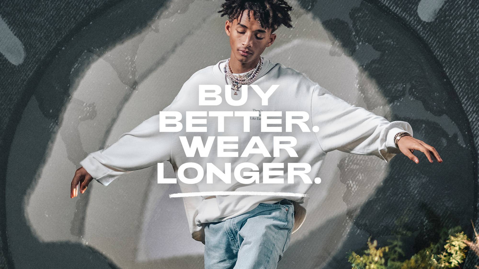A photo of Jayden Smith wearing a grey sweatshirt with his arms spread out and the words, "Buy Better. Wear Longer." overlaid on the image.