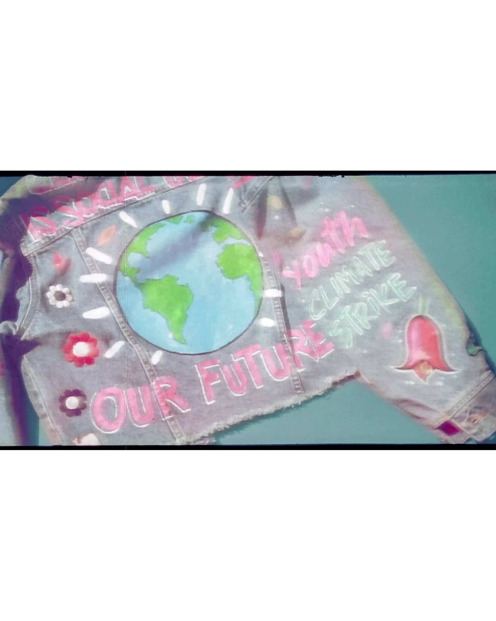 A gif of the back of Xiye's custom Levi's Trucker jacket showing the painted on words, "Climate Justice is Social Justice", "Our Future", and "Youth Climate Strike" additionally the back of the jacket features a painting of the globe.