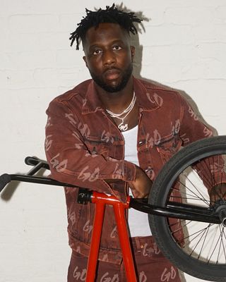 Nigel standing with a red BMX bike.