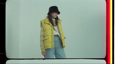 MP4 of woman wearing a yellow puffy jacket and a black bucket hat.