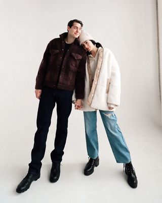 Gabe James and Luann Diez standing, holding hands in cold weather styled outfits against a white backdrop