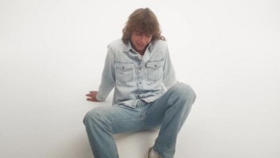 Five different colored sherpa jackets hanging on a rack.