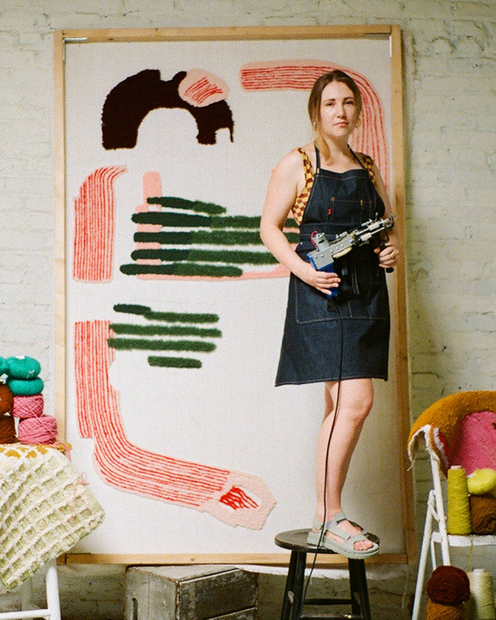 Caroline Kaufman wearing a levis denim overalls displaying her work