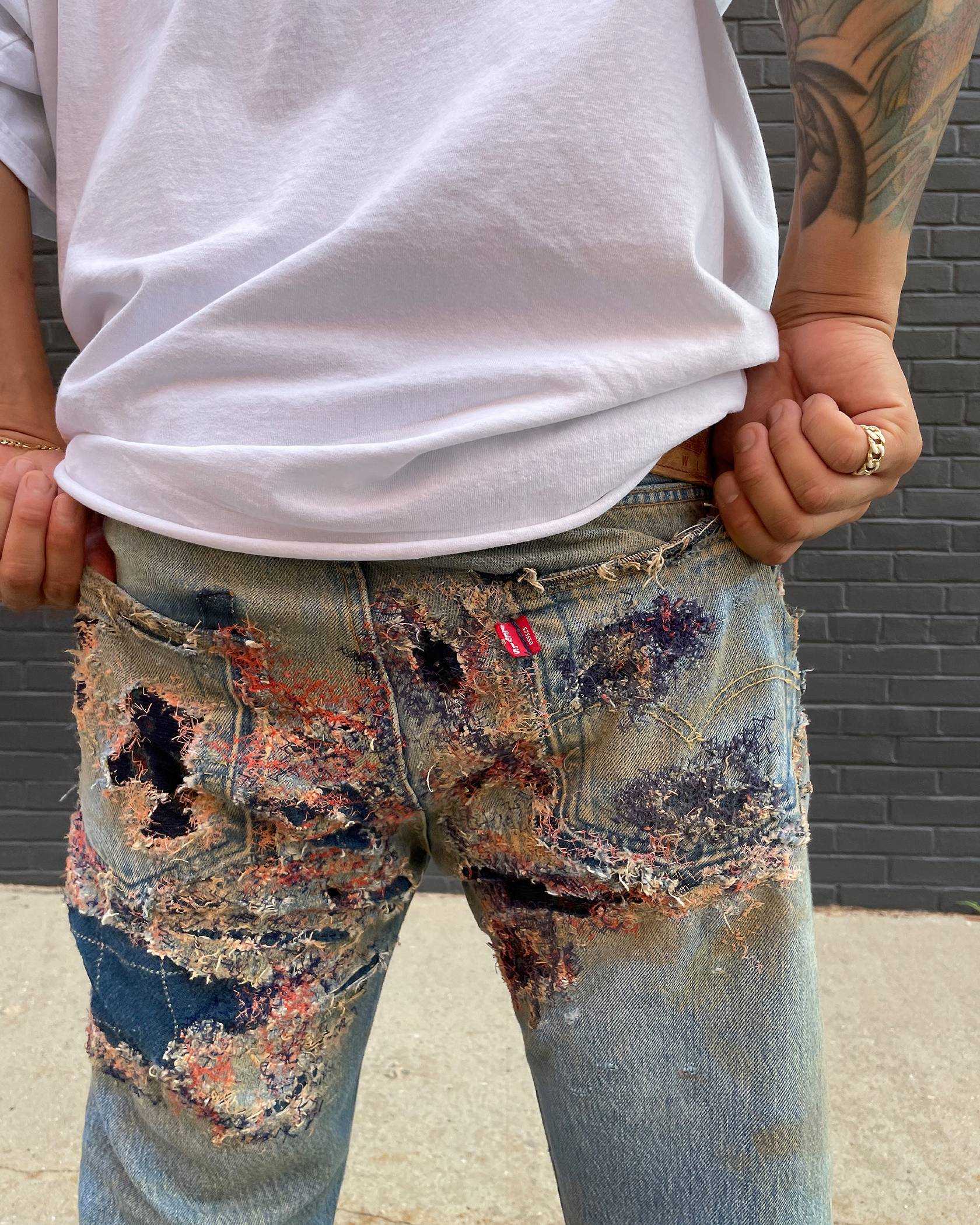 Phillip Leyesa in a close-up shot of back pockets with the Levi's red tab logo still on the Levi's 501 Jeans after his customization process showing detailed distressed effect.