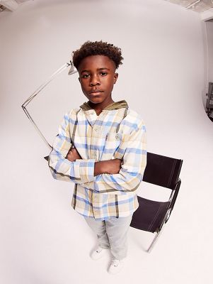 Model wearing plaid shirt and light wash blue jeans