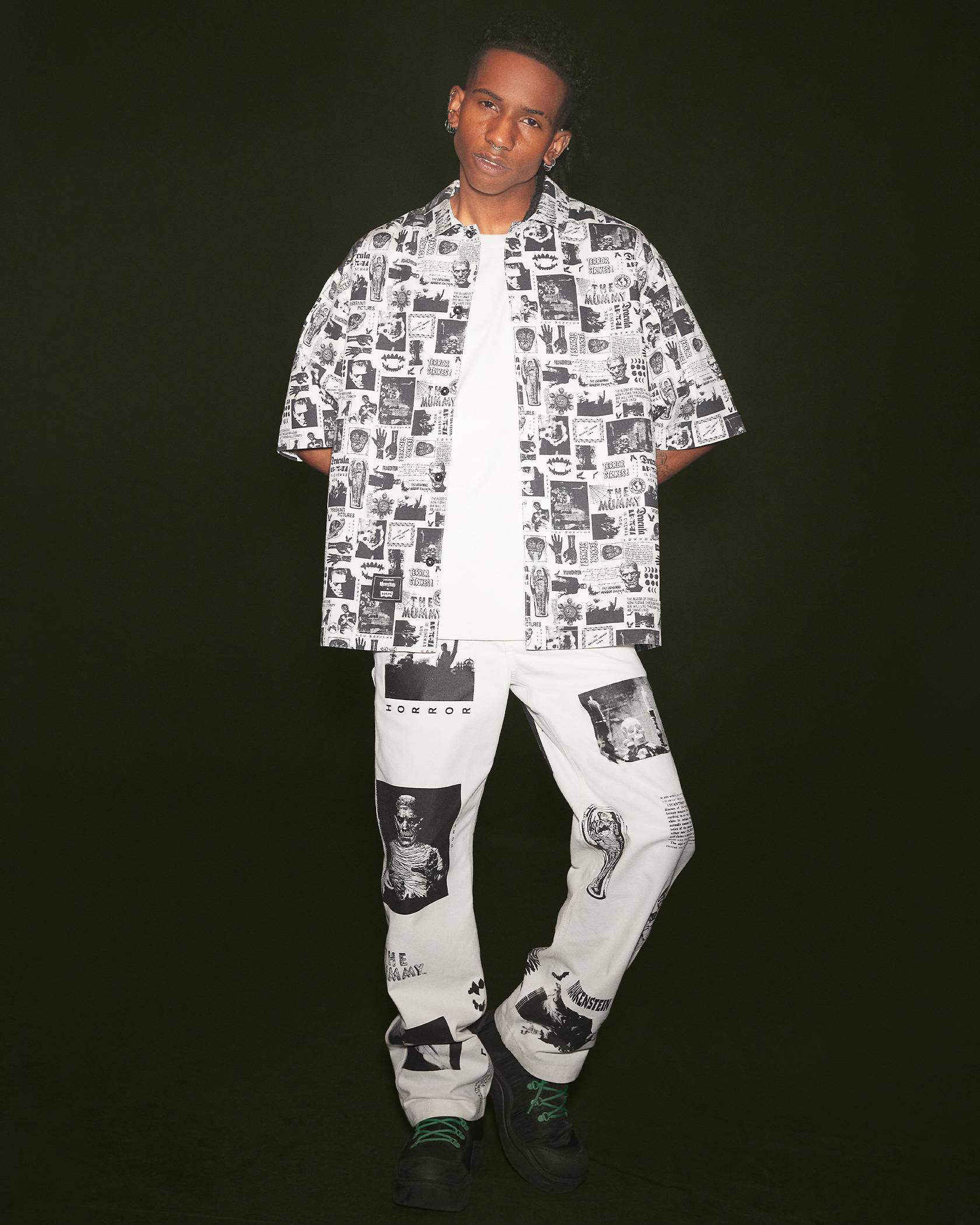 Image of man wearing clothing with graphic spooky prints against black background