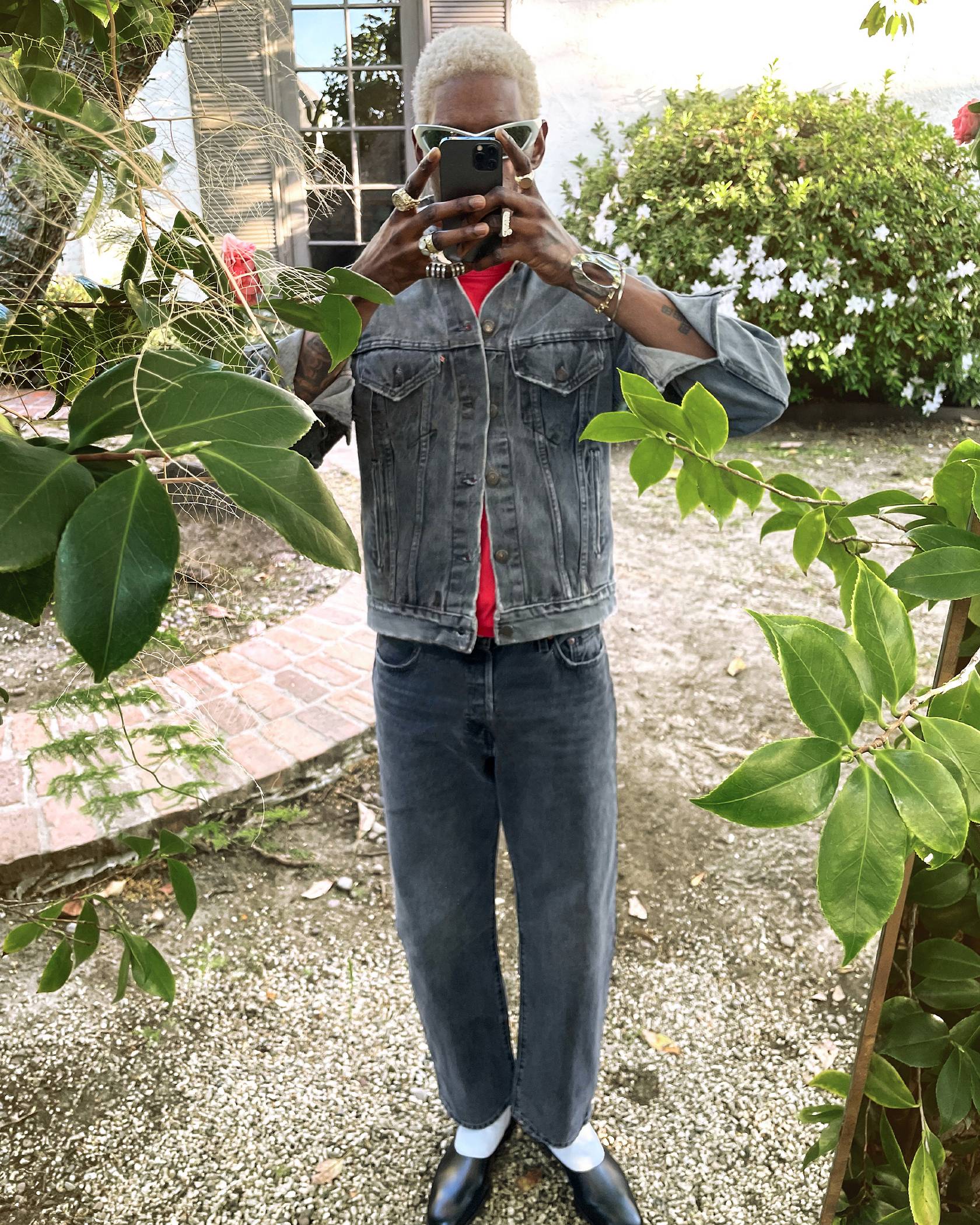 Image of man outdoors taking photo of his styled denim look
