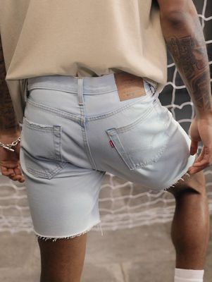 Close up butt shot of model wearing light wash 501 shorts and tan shirt