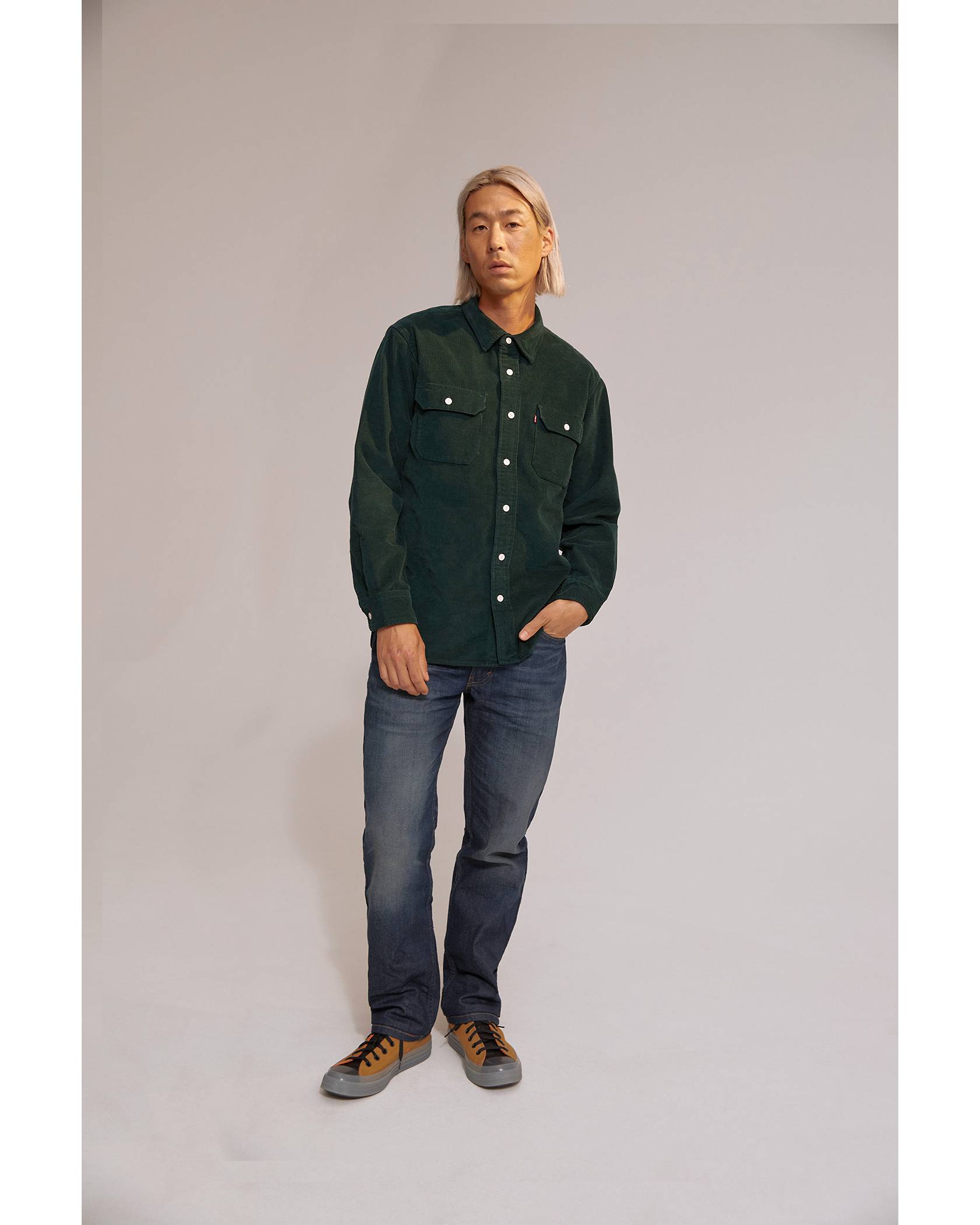 Model wearing green button down and dark wash jeans