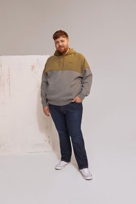 Model wearing green and gray sweatshirt with Levi's logo and dark wash jeans