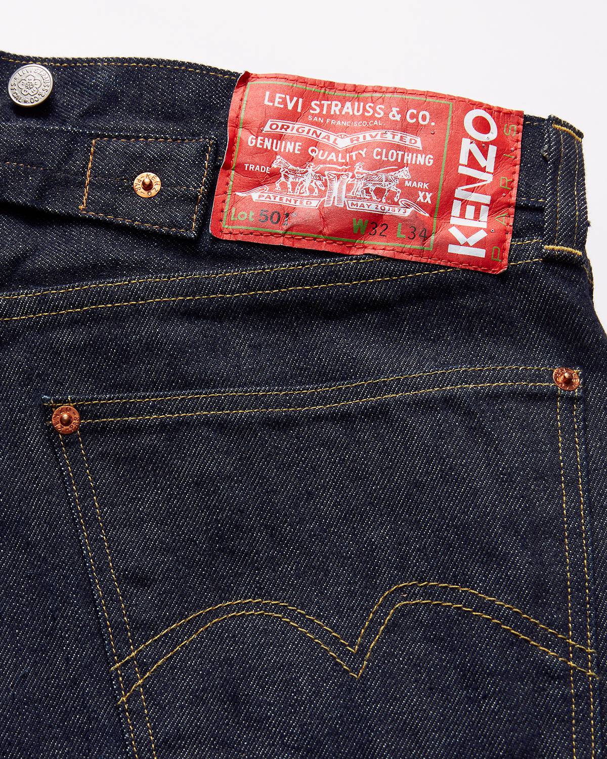Image of the KENZO x Levi's® collaboration showing the back pocket of a pair of a dark wash denim jeans and bright red backpatch.