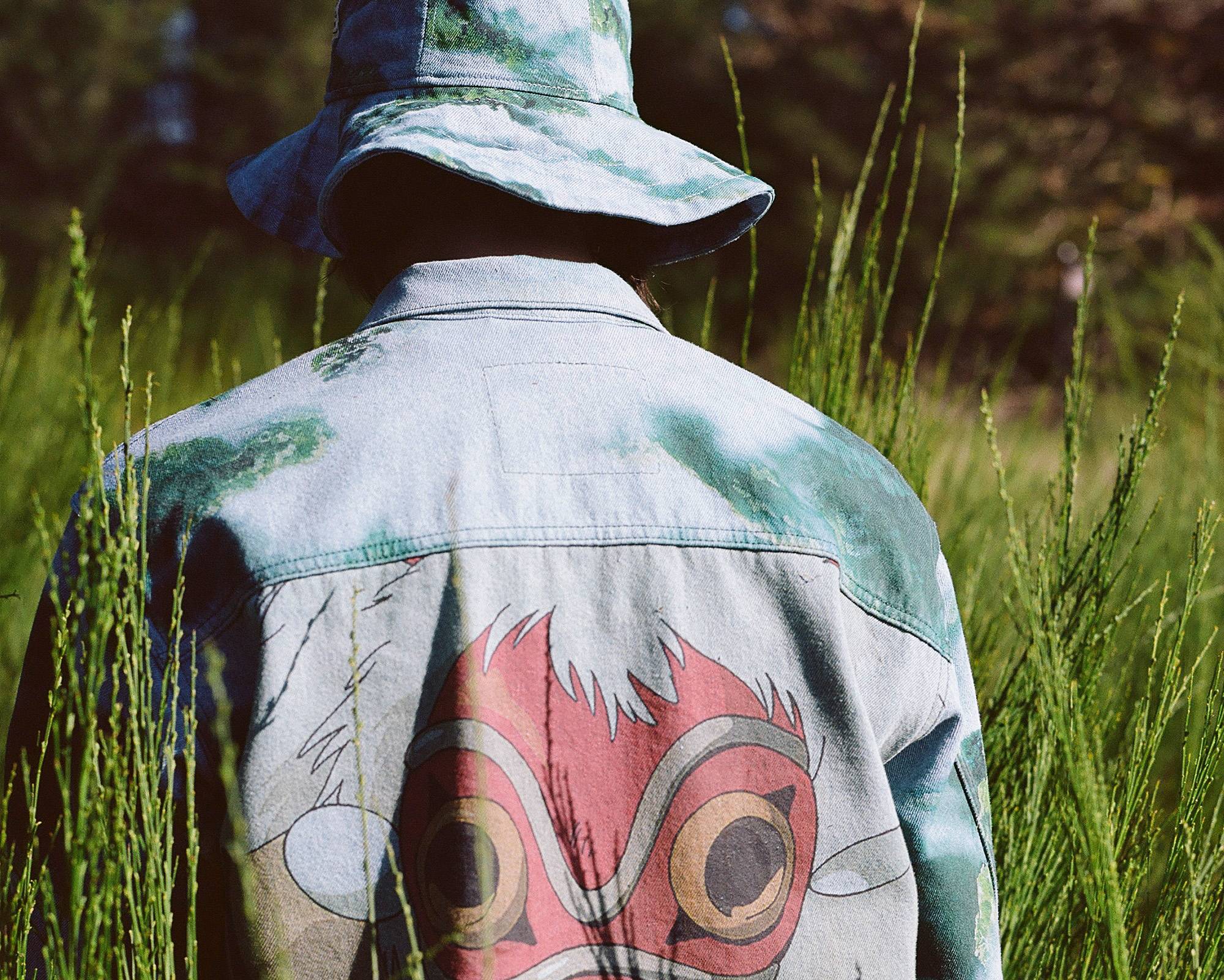 Image of person wearing Levi's® x Princess Mononoke collection piece and posing in forest setting