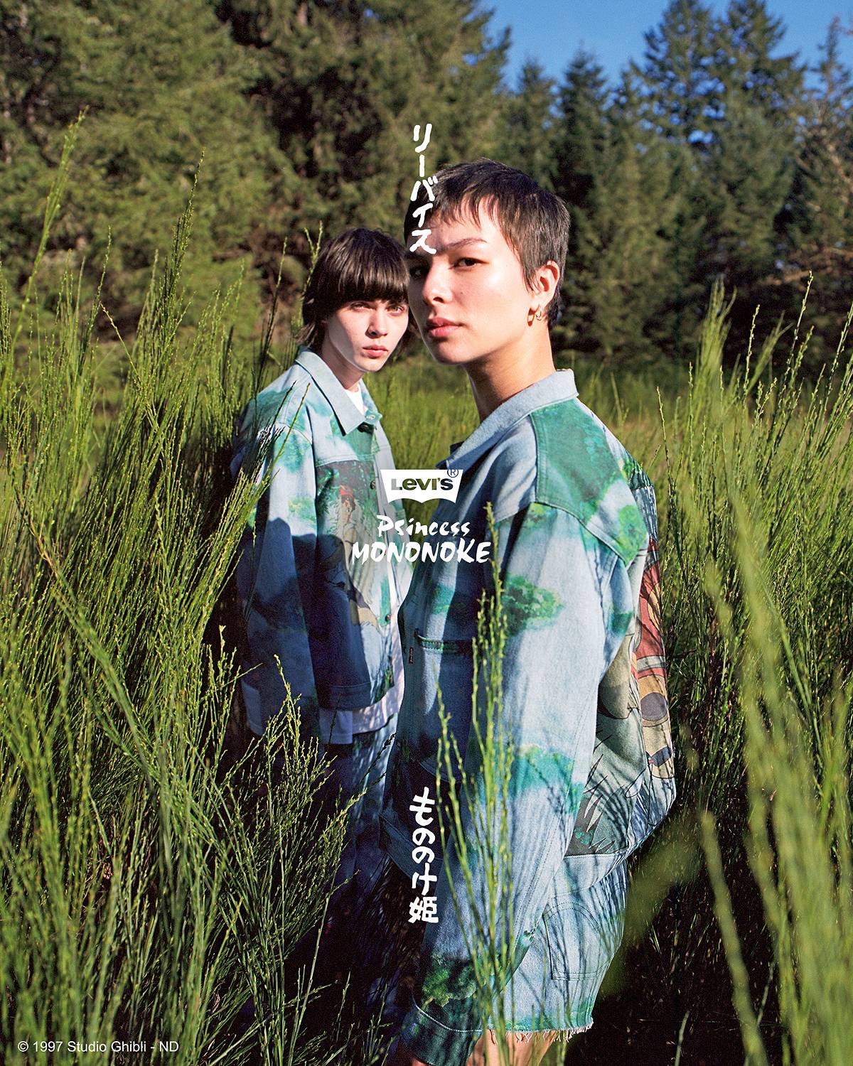 Image of two models wearing the Levi's® x Princess Mononoke collaboration trucker jackets, standing in a field of tall green grass.