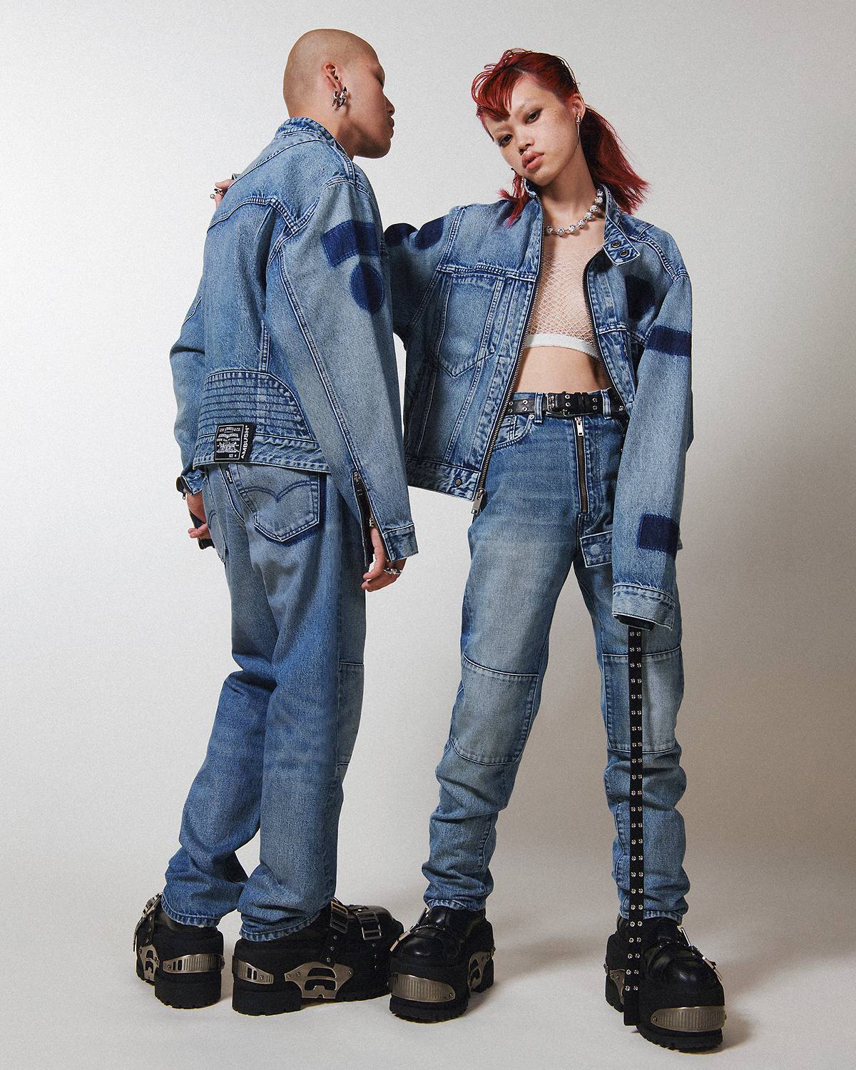 Two models wearing head-to-toe Levi's® x AMBUSH® denim, including a medium wash trucker jacket and medium wash Levi's® jeans. 