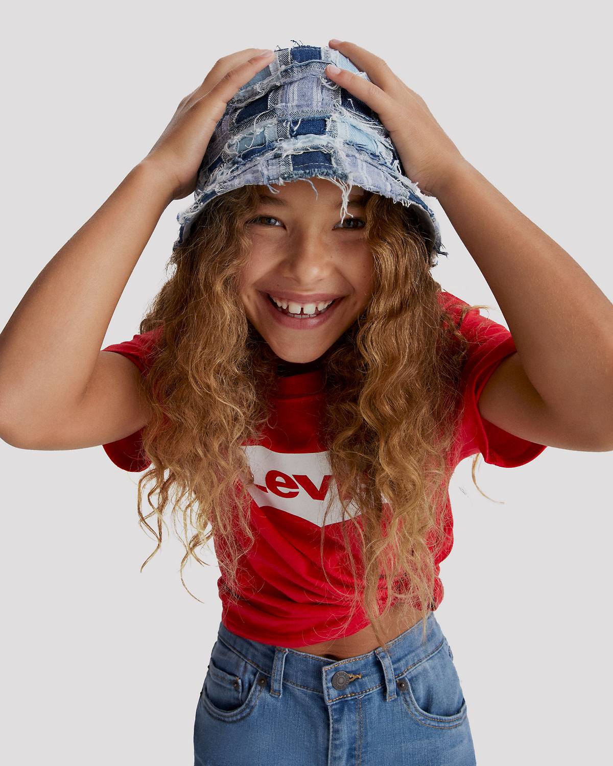 Model in kids' red logo tee and jeans