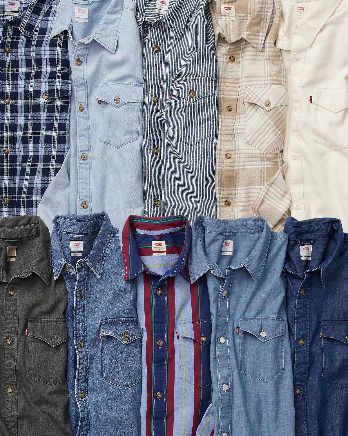 Flat lay image of assorted men's western woven button down shirts in numerous colors and patterns