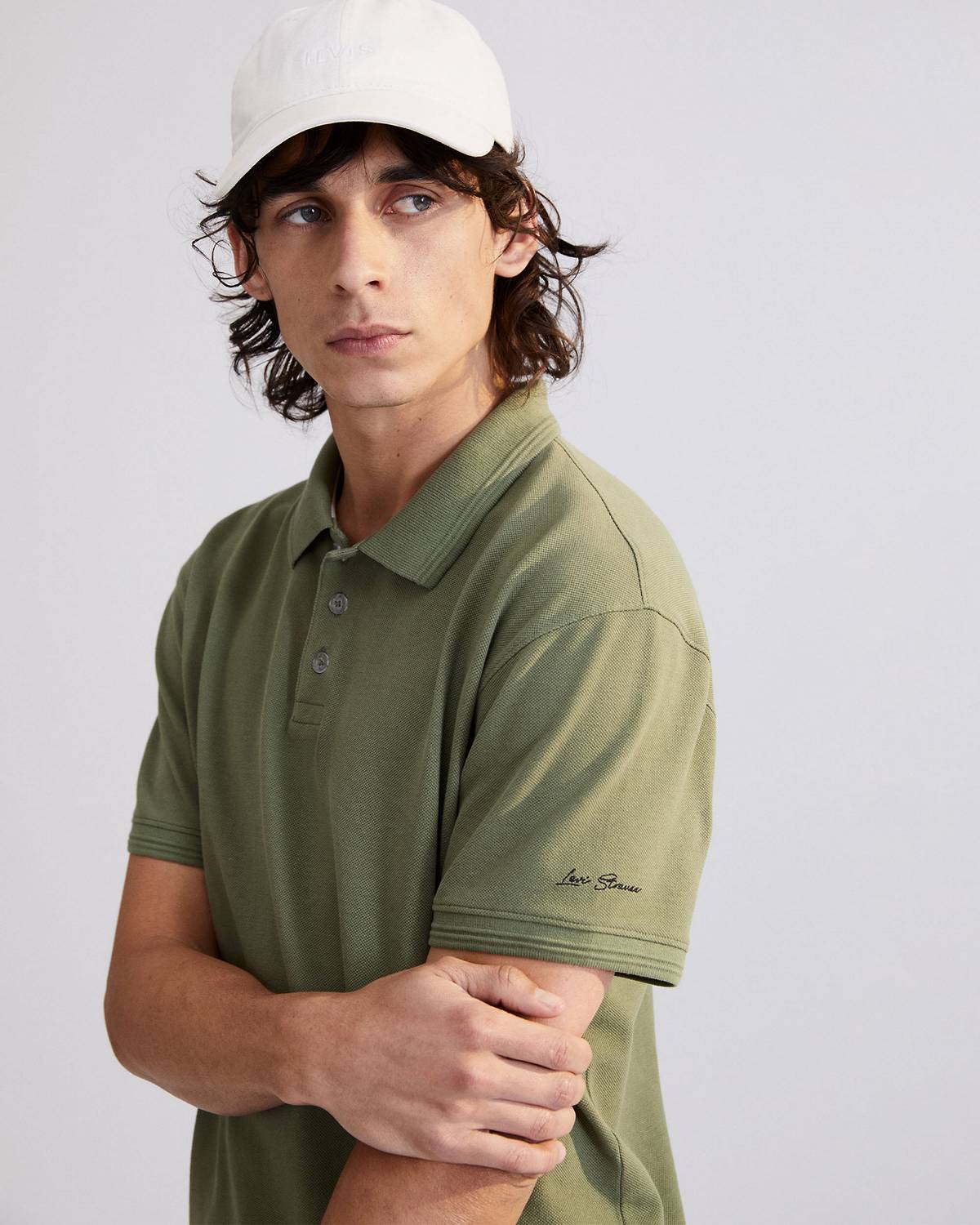 Model in white cap & men's green polo