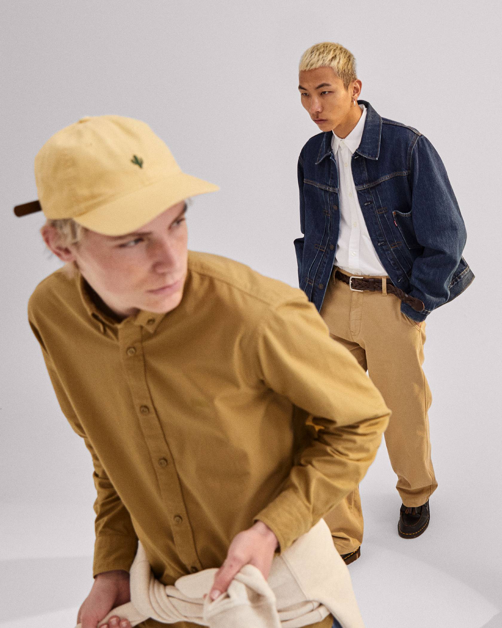 Models in men's clothing - embroidered cap, tan button down shirt, Levi's® XX Chinos and navy coat