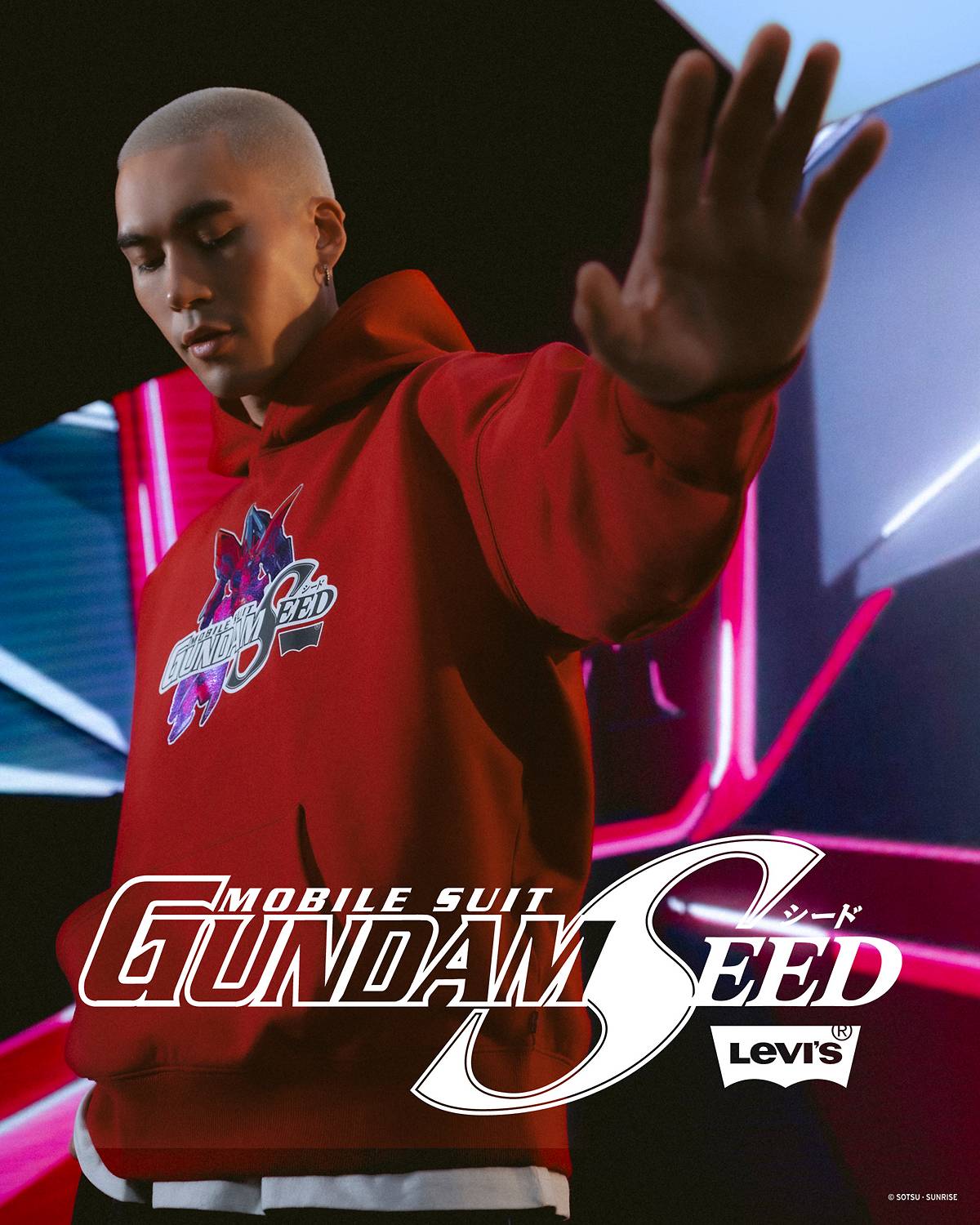 Image of a model reaching out to the camera, wearing the red Levi's x Gundam SEED collaboration hoodie.