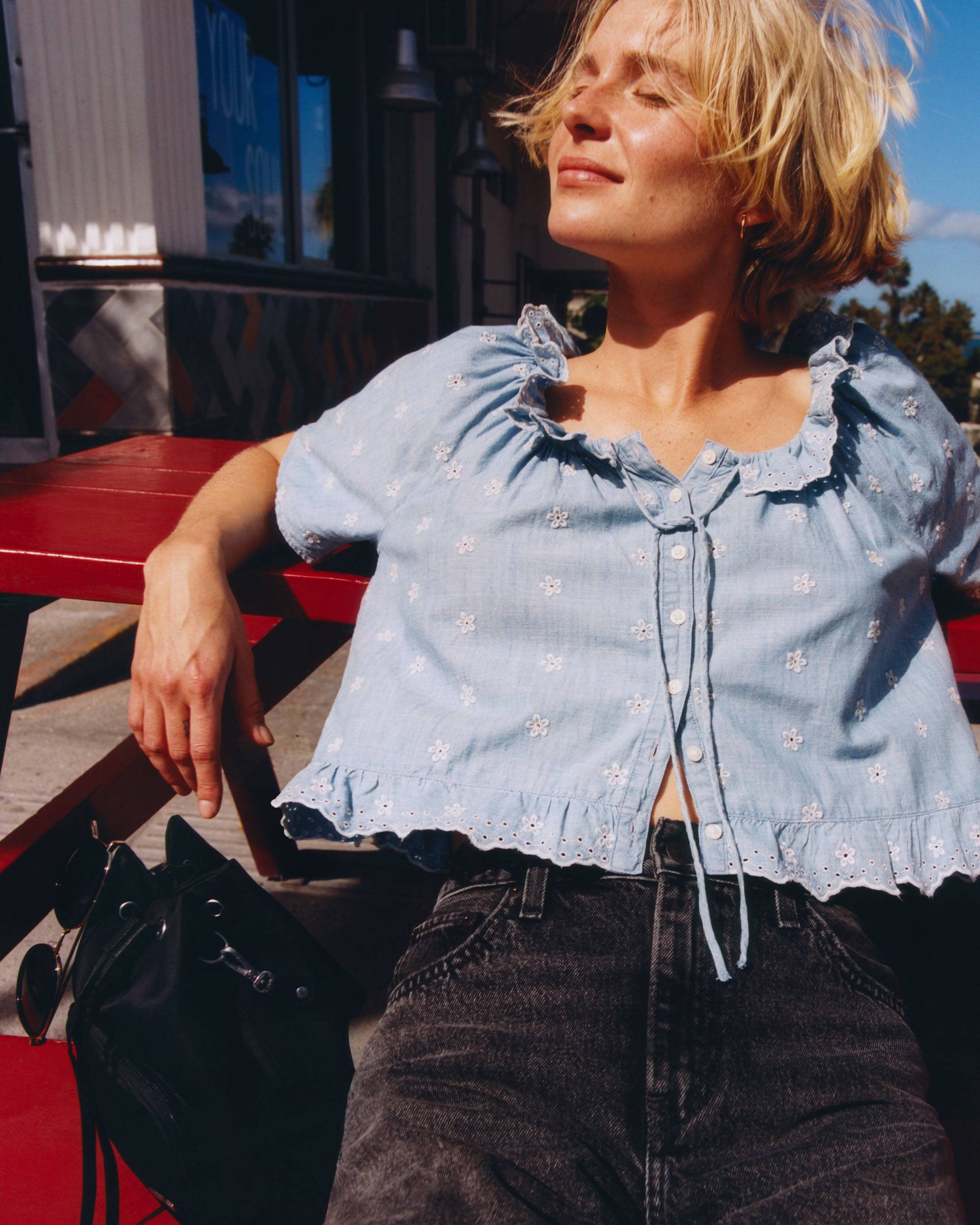 Model in ruffled collar chambray blouse