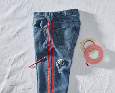 pair of jeans laying down with tape on sides