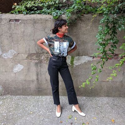 Photo of Tahia Islam standing against a concrete wall outside.