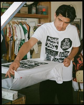 Guy standing with shirt in his hand.