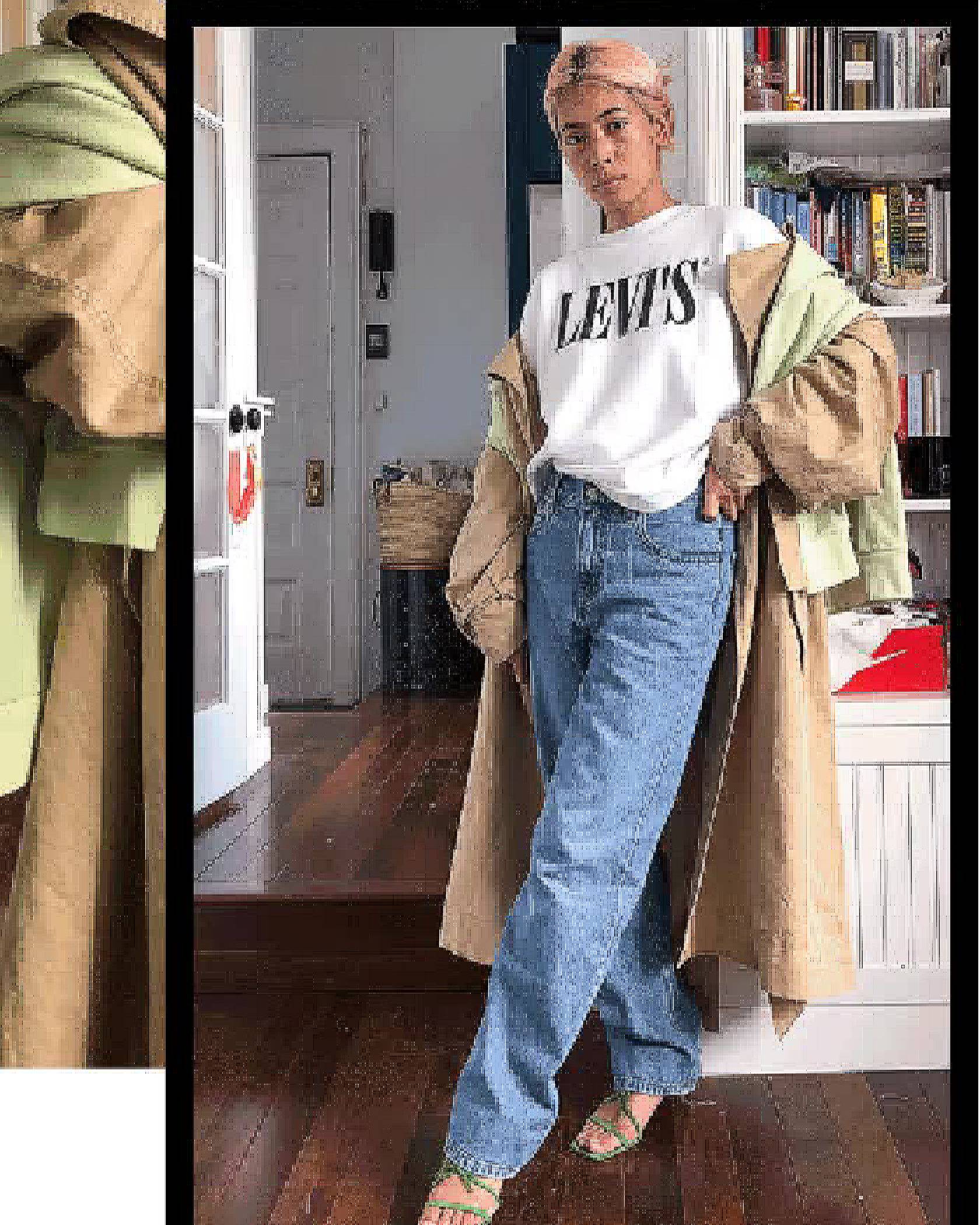 Michelle Li standing in her house wearing a Levi's sweatshirt, a long trench coat and Levi's loose jeans